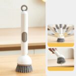 Adjustable kitchen cleaning brush with soap dispenser on countertop