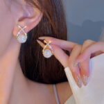 Golden cross pearl zircon stud earrings front view
