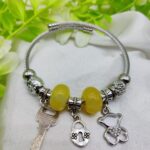 Elegant Pandora charm bracelet with yellow beads and teddy bear charm