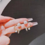 Golden Korean fishtail stud earrings with simulated pearl and butterfly design front view