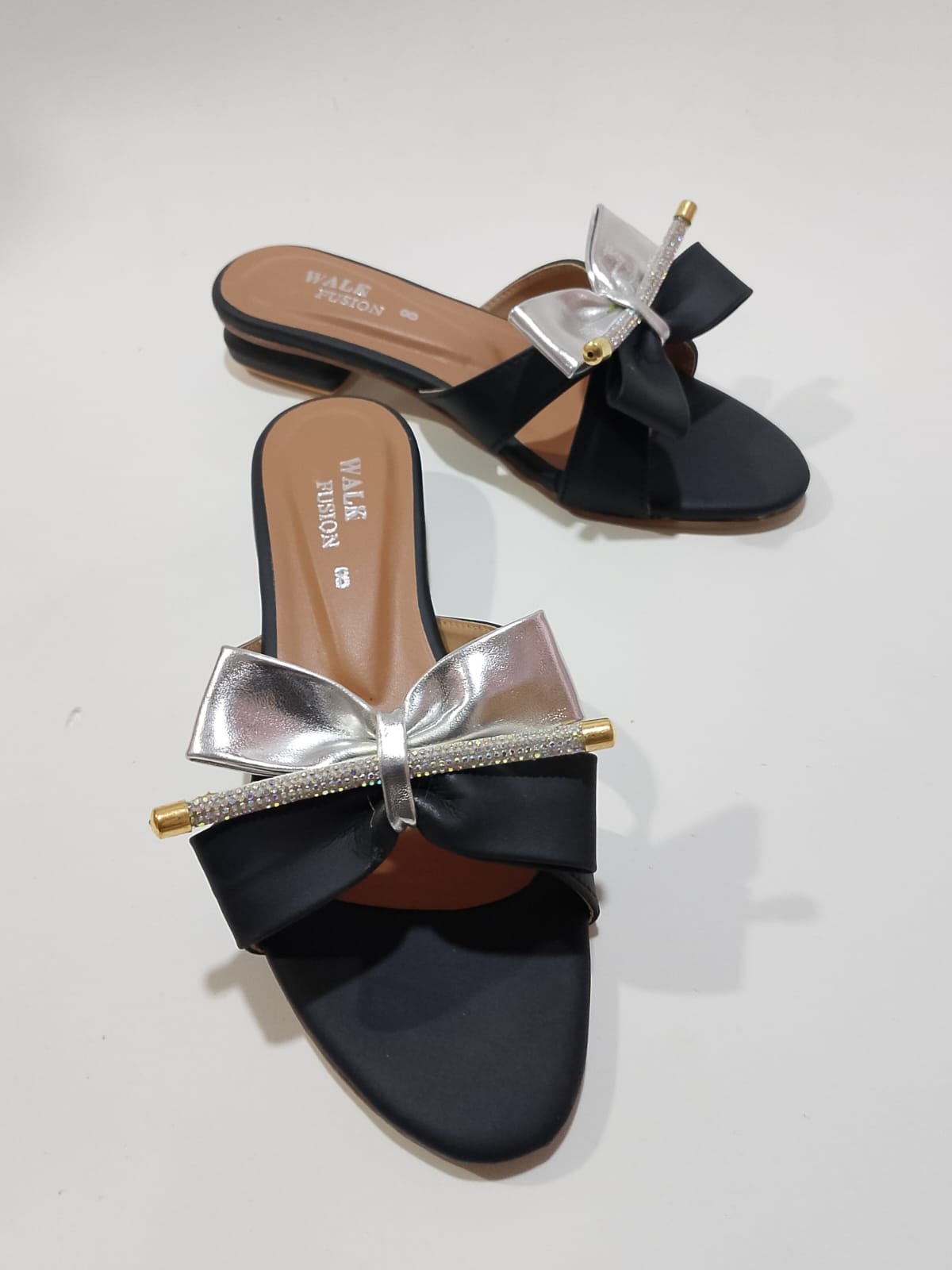 WhatsApp-Image-2025-08-18-at-3.19.36-PM-2.jpeg Black slide sandal with metallic silver bow and crystal detail side view