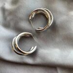 Punk oval metallic hoop earrings on white background