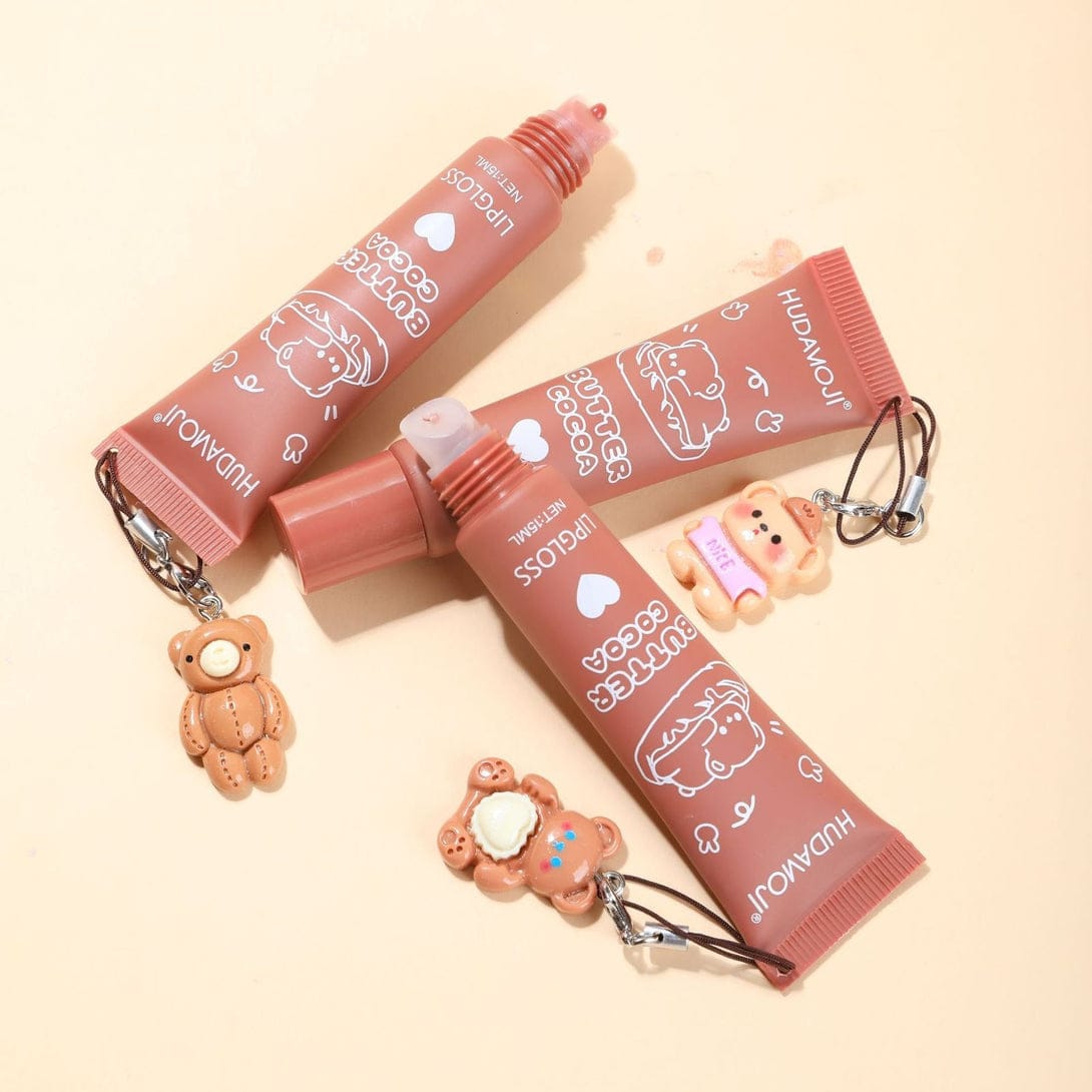 f7e34b0810e1b316dae8450557d3bd37.jpeg Huda Moji Cute Teddy Style Cocoa Butter High Pigmented Lip Gloss Set – Nude Shades (Pack of 2) - Image 1